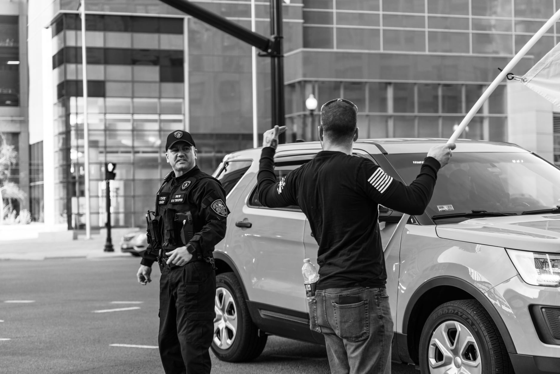 State trooper watching protester with flag