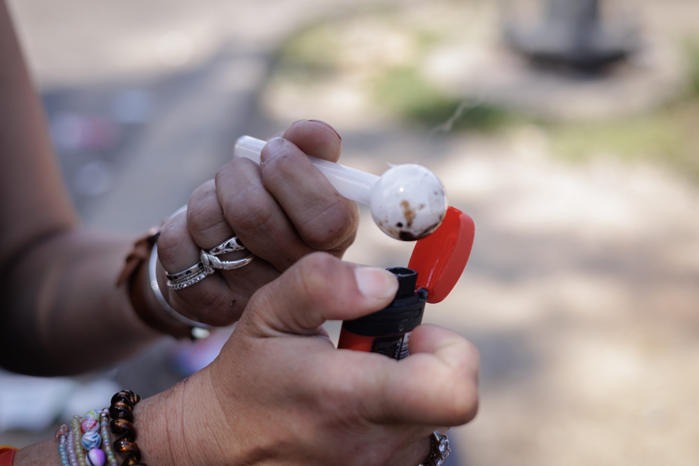 Hand holding pipe and lighter