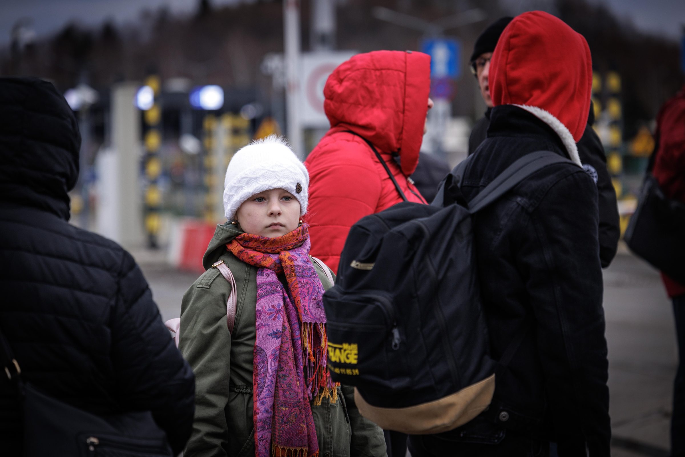 Girl in white hat staring forward at the border